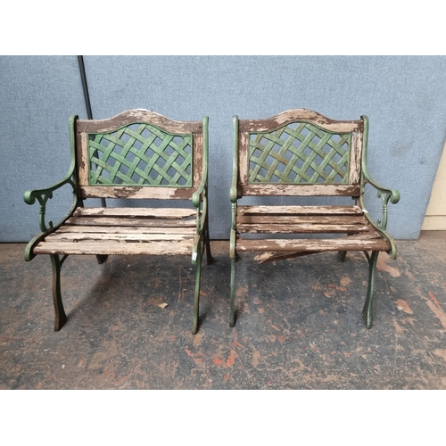 771 - A pair of cast iron and wooden slatted garden armchairs - approx. 80cm high x 58cm wide x 54cm deep