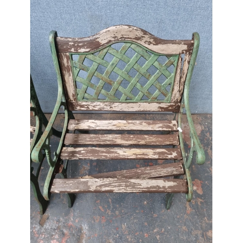 771 - A pair of cast iron and wooden slatted garden armchairs - approx. 80cm high x 58cm wide x 54cm deep