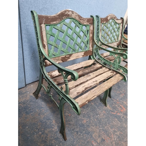 771 - A pair of cast iron and wooden slatted garden armchairs - approx. 80cm high x 58cm wide x 54cm deep