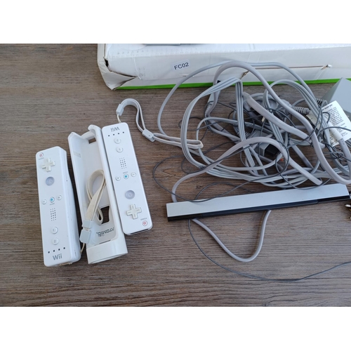 575 - A collection of Nintendo Wii items to include console, two Wii remotes, sensor bar, power adapter, b... 