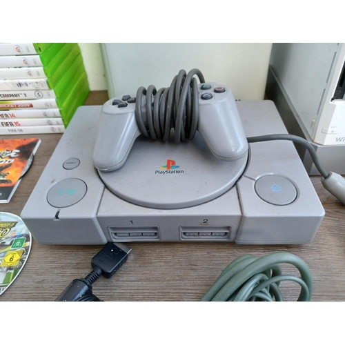 576 - A collection of games consoles, games and accessories to include Sony Playstation console with contr... 