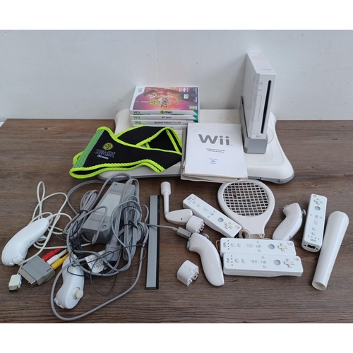 577 - A collection of Nintendo Wii items to include console with stand, three Wii remotes with nunchucks, ... 