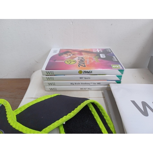 577 - A collection of Nintendo Wii items to include console with stand, three Wii remotes with nunchucks, ... 