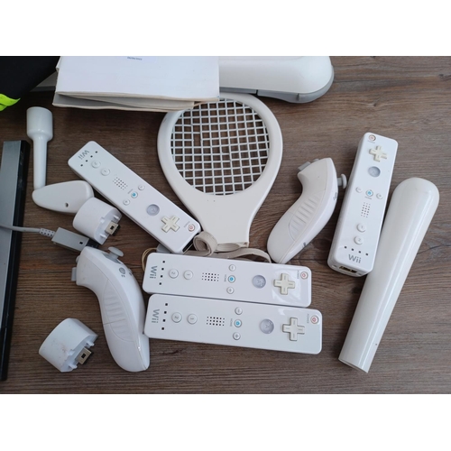 577 - A collection of Nintendo Wii items to include console with stand, three Wii remotes with nunchucks, ... 