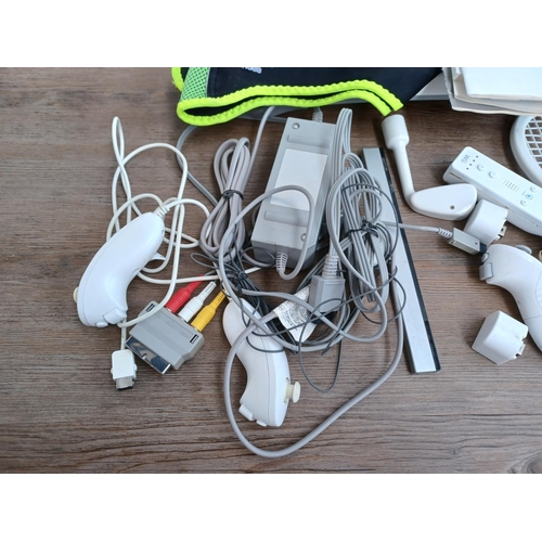 577 - A collection of Nintendo Wii items to include console with stand, three Wii remotes with nunchucks, ... 