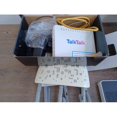 592 - A box containing a collection of wireless routers, ethernet adapters and accessories