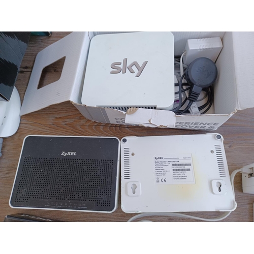 592 - A box containing a collection of wireless routers, ethernet adapters and accessories