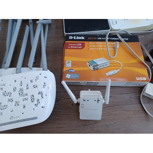 592 - A box containing a collection of wireless routers, ethernet adapters and accessories