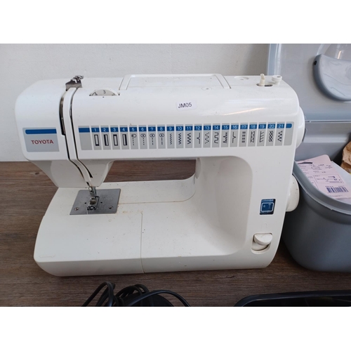 639 - Two items, one Toyota RA41 electric sewing machine with foot pedal and power cable and one sewing bo... 