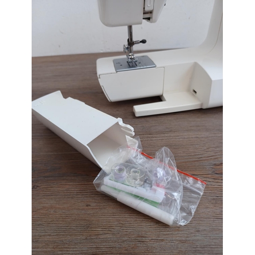 643 - A Jenome Jem electric sewing machine with foot pedal, power cable and cover