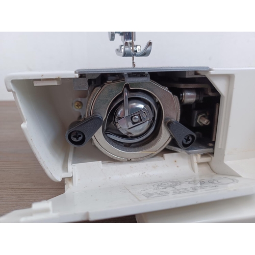 643 - A Jenome Jem electric sewing machine with foot pedal, power cable and cover