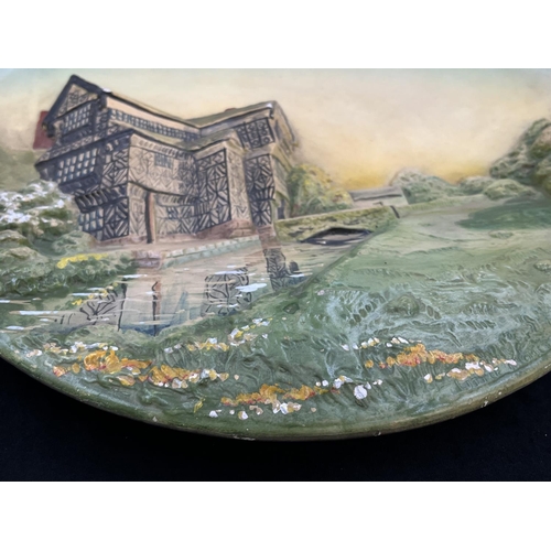 141 - A 1948 Bossons Little Moreton Hall, Cheshire chalkware wall plaque - approx. 36.5cm diameter