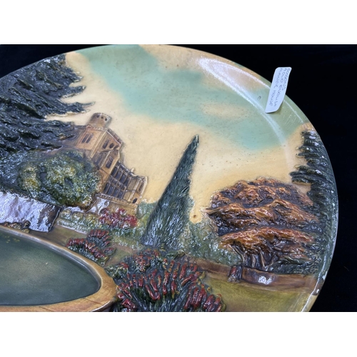 25 - A 1955 Bossons Old English Manor House chalkware circular wall plaque - approx. 36.5cm diameter