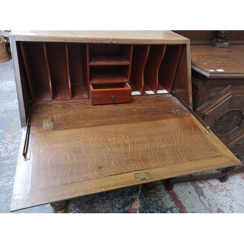 351 - A mid 20th century carved oak bureau with three drawers, fall front and baluster supports - approx. ... 