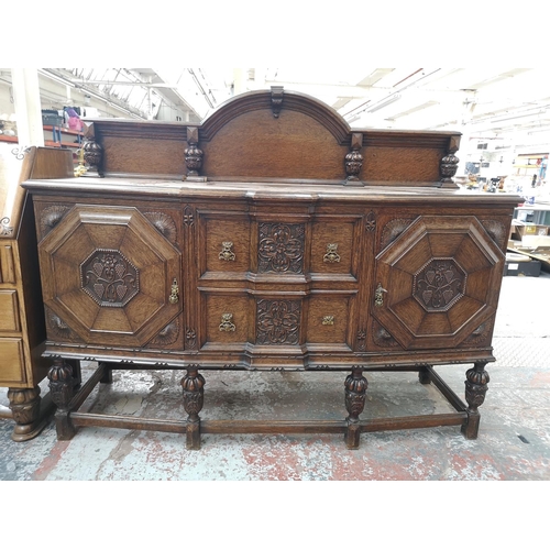 352 - An early 20th century carved oak sideboard with baluster supports, two central drawers and two outer... 