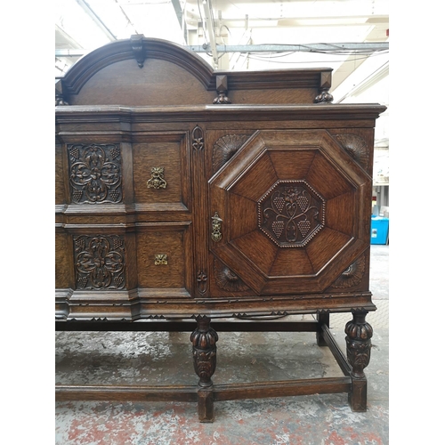 352 - An early 20th century carved oak sideboard with baluster supports, two central drawers and two outer... 