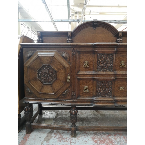 352 - An early 20th century carved oak sideboard with baluster supports, two central drawers and two outer... 