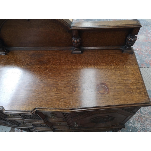 352 - An early 20th century carved oak sideboard with baluster supports, two central drawers and two outer... 