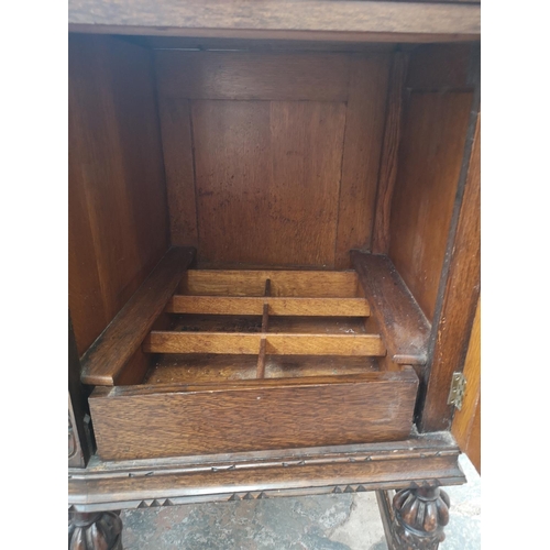 352 - An early 20th century carved oak sideboard with baluster supports, two central drawers and two outer... 