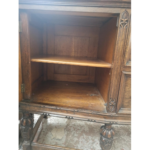 352 - An early 20th century carved oak sideboard with baluster supports, two central drawers and two outer... 