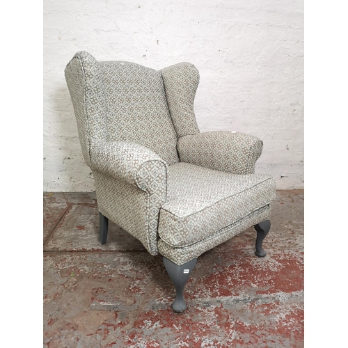 391 - A mid 20th century floral upholstered wingback armchair with grey painted cabriole supports - approx... 