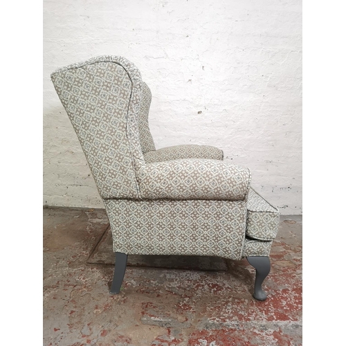 391 - A mid 20th century floral upholstered wingback armchair with grey painted cabriole supports - approx... 