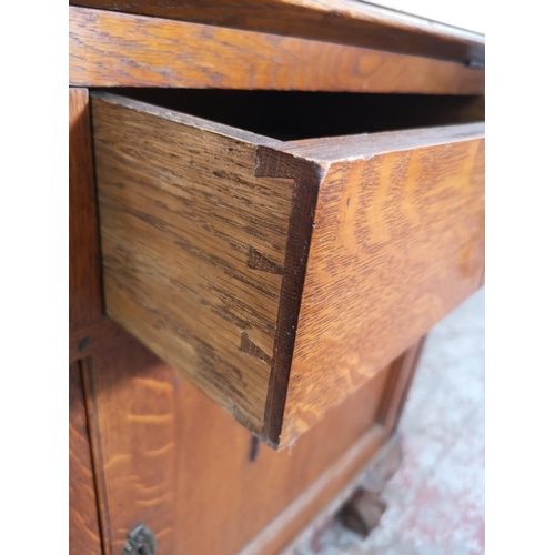 401 - An early/mid 20th century oak bureau with two drawers, two cupboard doors, fall front, ball and claw... 