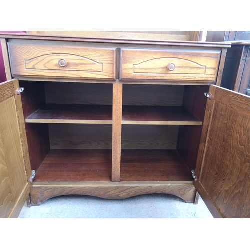 411 - An oak dresser with two drawers, two cupboard doors and upper two tier plate rack - approx. 165cm hi... 