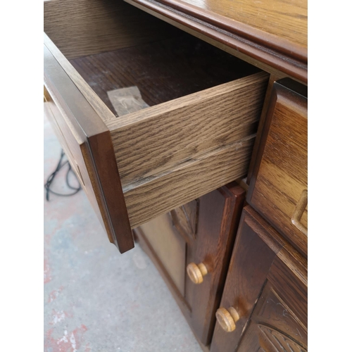 411 - An oak dresser with two drawers, two cupboard doors and upper two tier plate rack - approx. 165cm hi... 