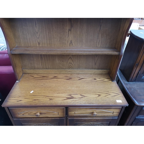 411 - An oak dresser with two drawers, two cupboard doors and upper two tier plate rack - approx. 165cm hi... 