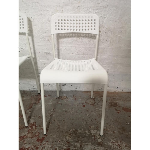 431 - A set of four IKEA Adde white plastic and metal stacking chairs