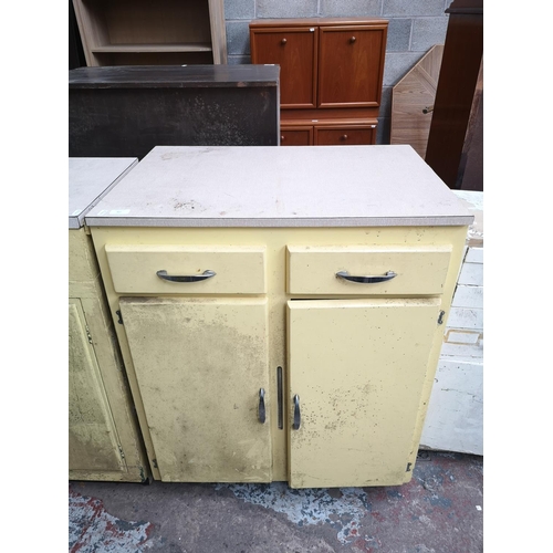 465 - A mid 20th century yellow painted and laminate kitchen cabinet with two drawers and two cupboard doo... 