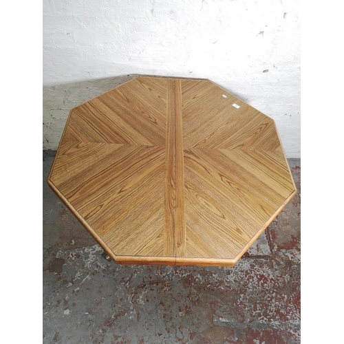 482 - An oak octagonal dining table on chrome plated supports