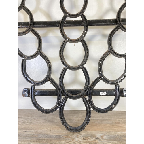 112 - A cast iron horseshoe wall hanging - approx. 100cm high x 96cm wide