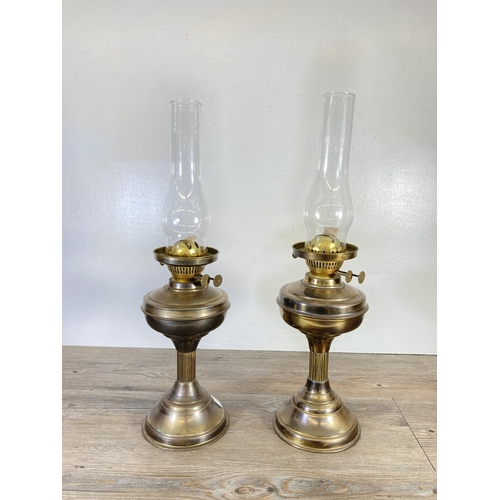 310 - A pair of brass oil lamps, one with milk glass shade and one with etched glass shade - approx. 54cm ... 