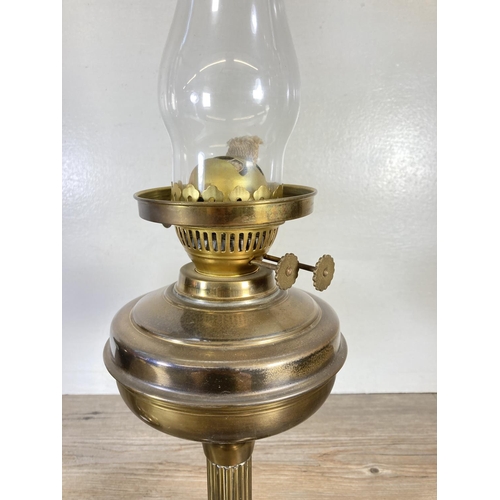 310 - A pair of brass oil lamps, one with milk glass shade and one with etched glass shade - approx. 54cm ... 