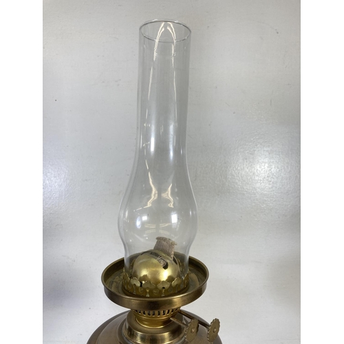 310 - A pair of brass oil lamps, one with milk glass shade and one with etched glass shade - approx. 54cm ... 