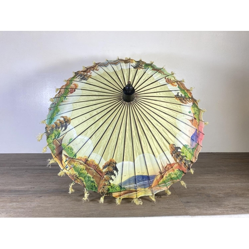 350G - Two oriental hand painted paper and bamboo items, one parasol - approx. 70cm in diameter and one fan... 