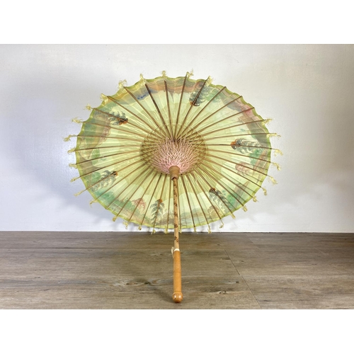 350G - Two oriental hand painted paper and bamboo items, one parasol - approx. 70cm in diameter and one fan... 