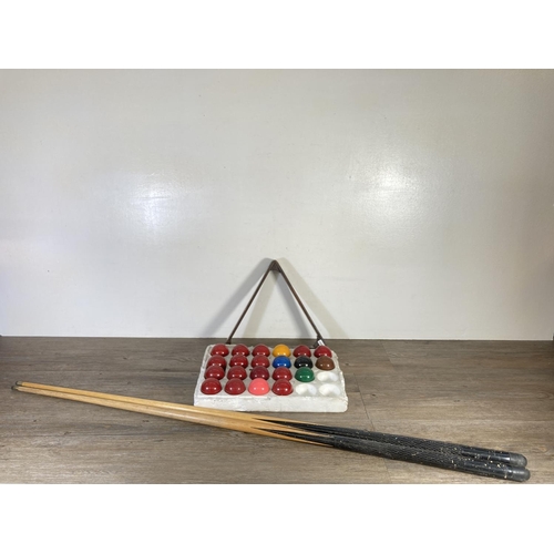 350K - Four pieces of snooker/pool equipment, two 125cm cues, one early 20th century mahogany triangle and ... 