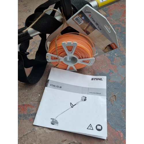 A Stihl FS 38 petrol strimmer with instruction manual, 2.4mm cord and