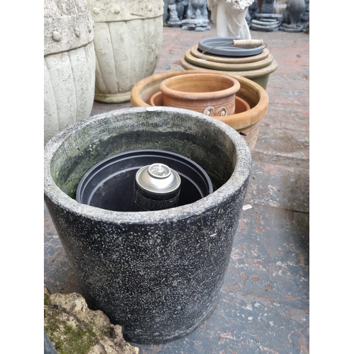 661 - A quantity of garden planters and ornaments to include cast stone tree slice stepping stones, terrac... 