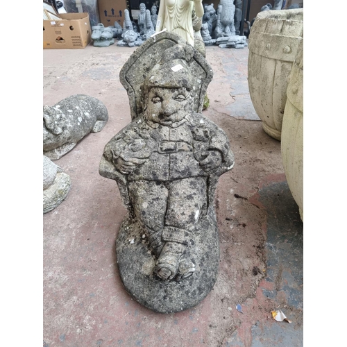 663 - A cast stone seated gnome garden ornament - approx. 42cm high