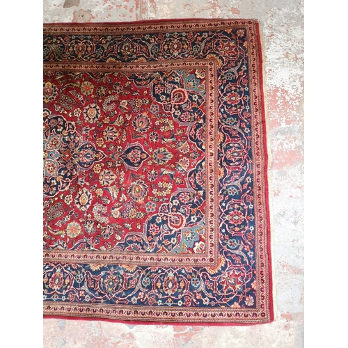 337 - A Persian style red and blue floral pattern rug - approx. 215cm x 142cm