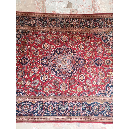 337 - A Persian style red and blue floral pattern rug - approx. 215cm x 142cm