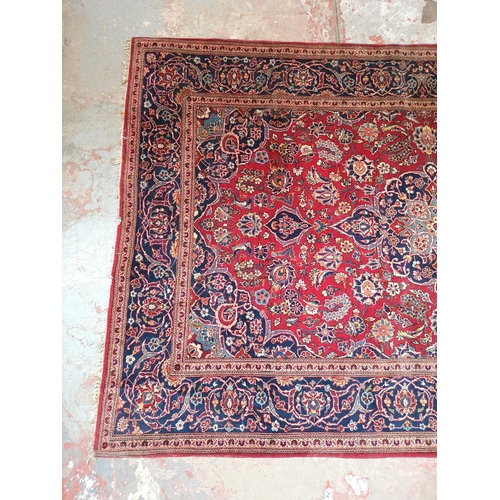 337 - A Persian style red and blue floral pattern rug - approx. 215cm x 142cm