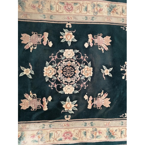 239 - An Oriental green and cream floral patterned rug - approx. 240cm x 155cm