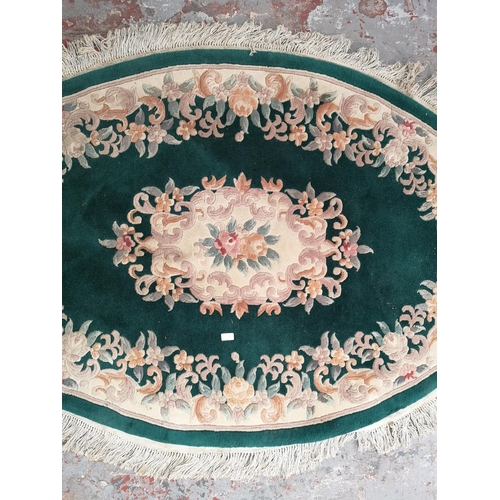 239A - A green and cream floral patterned oval rug - approx. 186cm x 125cm