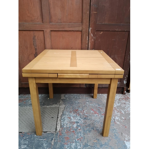 241 - A modern oak effect extending dining table with four matching chairs - approx. 76cm high x 80cm x 80... 