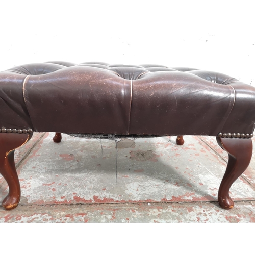 262 - A brown leather Chesterfield footstool with cabriole supports